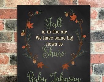 May include: A black chalkboard with a fall-themed wreath and the text "Fall is in the air. We have some big news to share Baby Johnson Due June 2021".