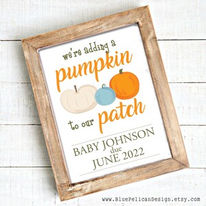 May include: A framed printable announcement with the text "We're adding a pumpkin patch to our Baby Johnson due June 2022". The announcement features a white background with green text and three pumpkins: one white, one orange, and one blue.