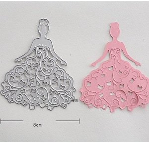 Puede incluir: Dos plantillas de metal troqueladas de una princesa con un vestido con intrincados dise&ntilde;os florales. Las plantillas miden 10 cm de alto y 8 cm de ancho.