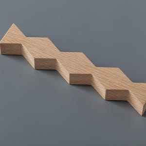 Pode incluir: Um objeto de madeira em forma de escada, de cor castanho claro. O objeto é feito de várias peças conectadas, cada uma com um ângulo ligeiramente diferente, criando um efeito de degraus.