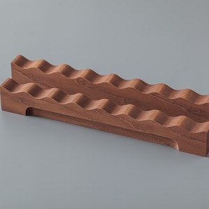 Peut inclure: Deux blocs rectangulaires en bois brun ondulés, empilés l'un sur l'autre. Les blocs ont une finition lisse et polie.