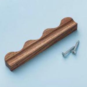 May include: A rectangular wooden drawer pull featuring a wavy, scalloped top edge and a natural brown wood grain finish. The handle includes two silver-colored metal screws for installation, positioned to the side of the wooden component.
