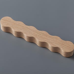 May include: A wooden, wavy, decorative handle with a light brown color.