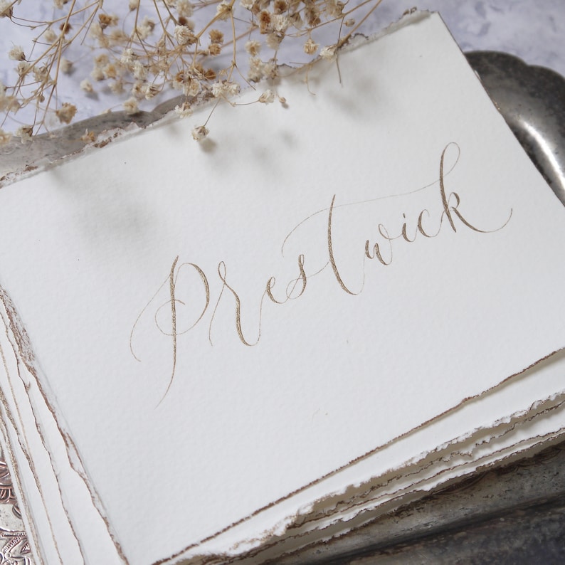 Calligraphy table sign on torn paper for weddings