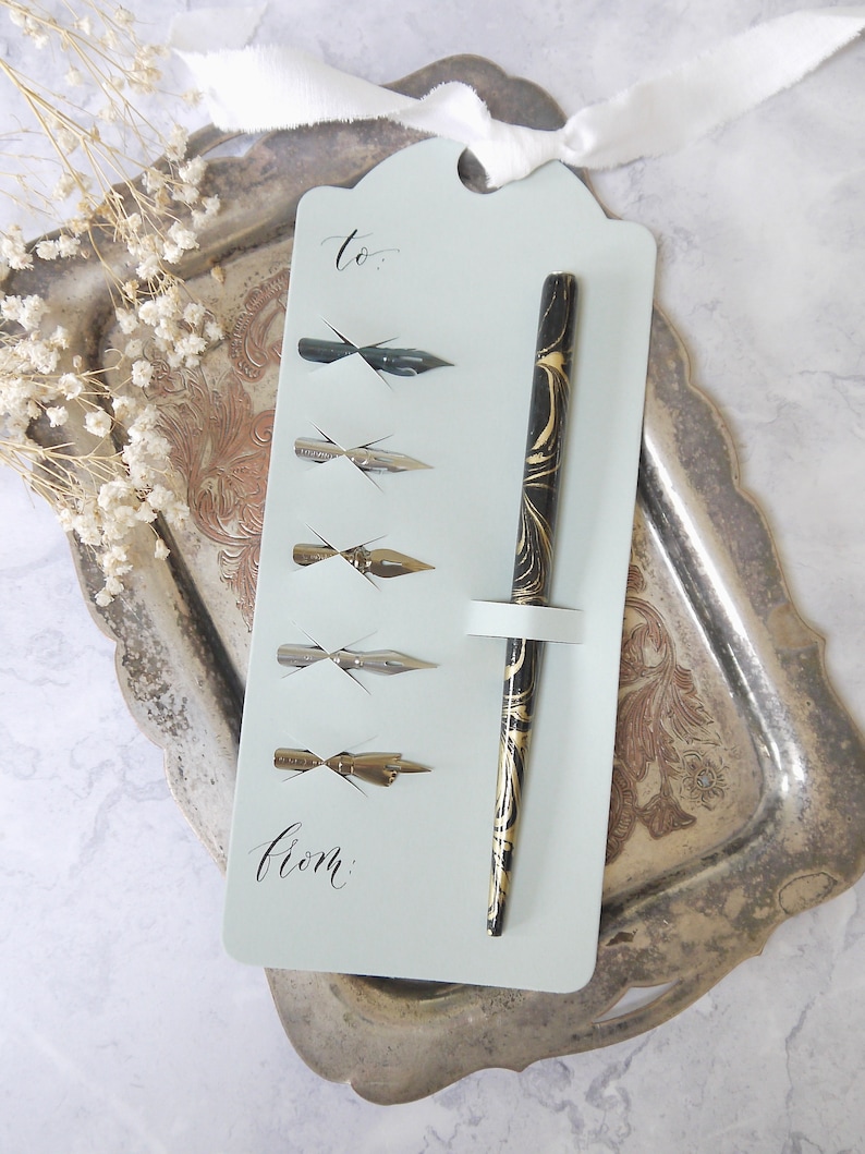 5 calligraphy nibs and a pen holder on a gift tag for beginners to use with ink