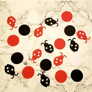 May include: Assortment of red, black, and white ladybug and circle confetti. The ladybugs have black spots and white accents. The circles are solid red, black, and white.