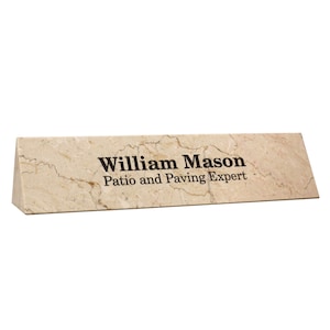 May include: A beige marble desk nameplate with the text "William Mason Patio and Paving Expert" engraved in black.