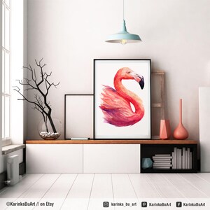 May include: A watercolor painting of a pink flamingo with a white background. The painting is framed in a black frame and is hanging on a white wall.