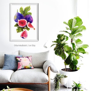 May include: Watercolor painting of a bunch of purple and pink figs with green leaves. The painting is framed and hanging on a white wall in a living room setting.