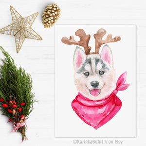 May include: Watercolor painting of a husky dog wearing a pink reindeer headband and a pink bandana. The dog is looking at the viewer with a happy expression.