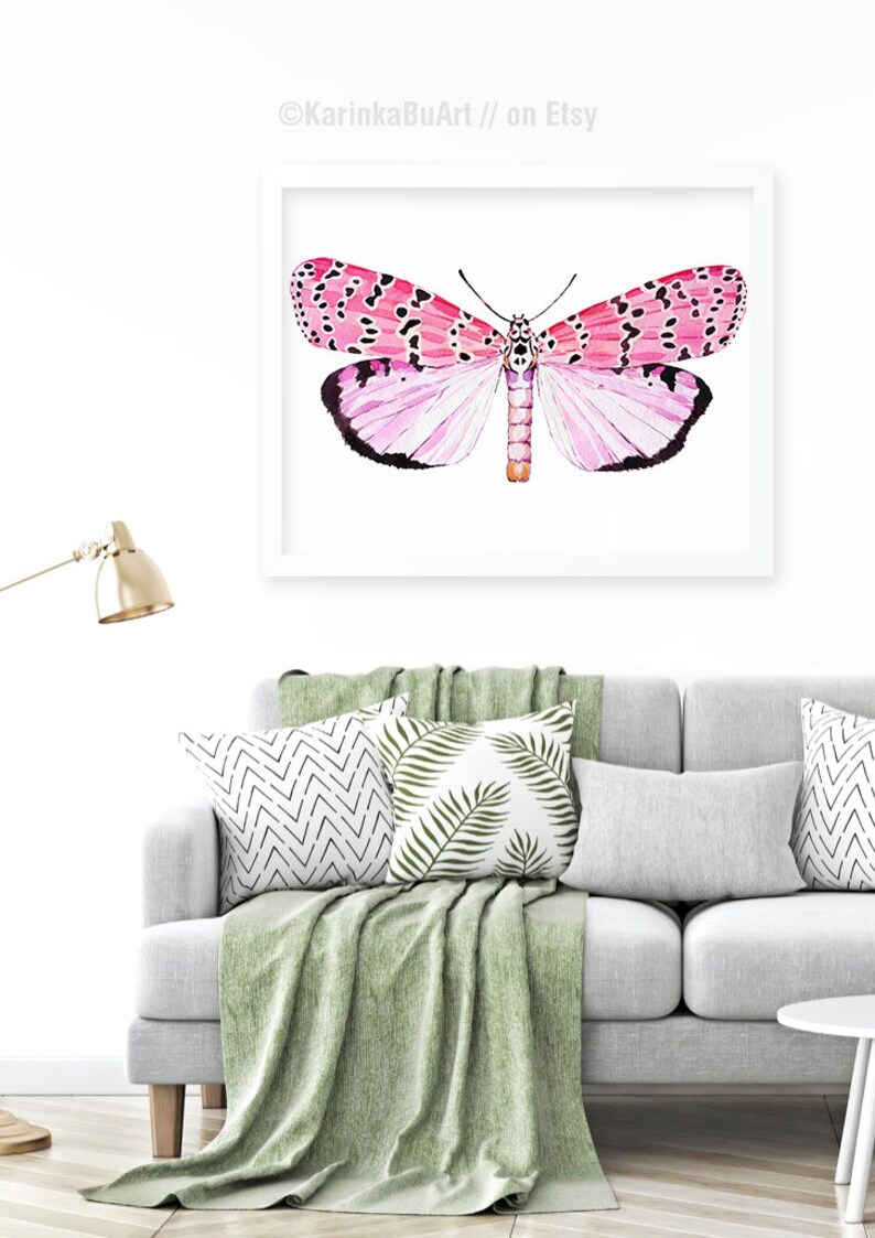 May include: A watercolor painting of a pink and black butterfly with white accents. The butterfly is centered on a white background with a white frame.