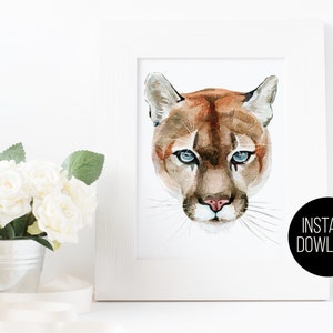 May include: Watercolor painting of a mountain lion with blue eyes. The painting is in a white frame and is ready for instant download.
