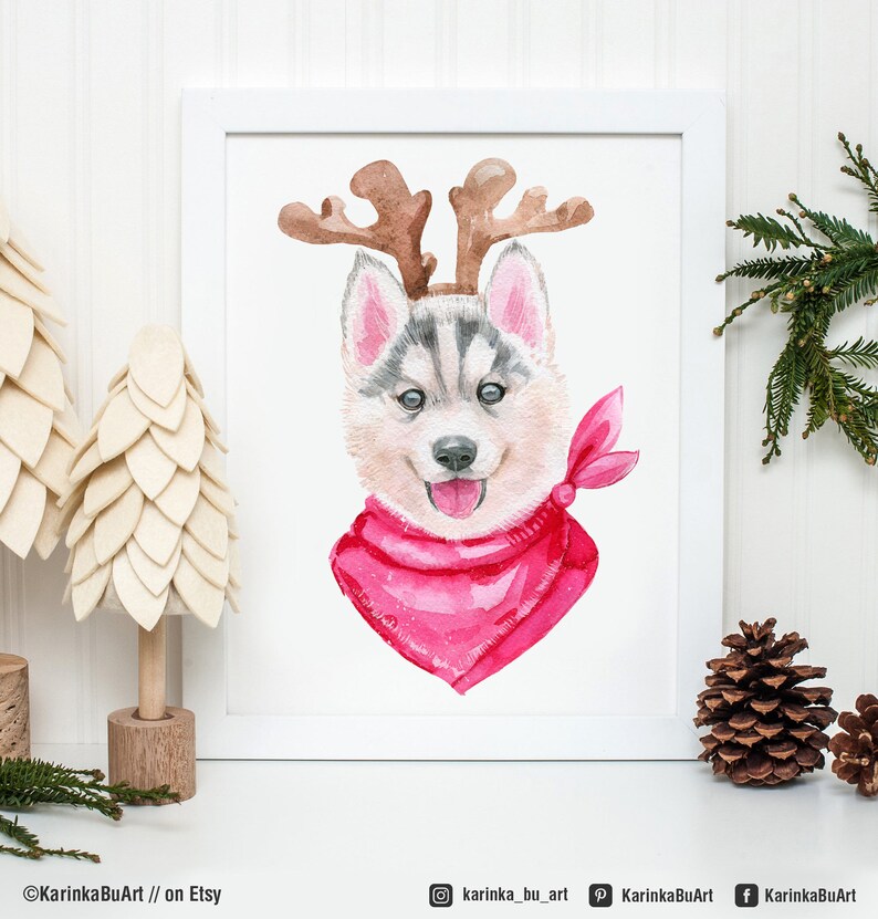 May include: Watercolor painting of a husky puppy wearing a red bandana and reindeer antlers. The puppy is looking at the viewer with a happy expression.