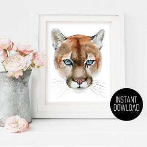 May include: A watercolor painting of a mountain lion's face. The lion has brown fur, blue eyes, and a pink nose. The background is white.