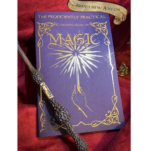 Deep purple book titled The Proficiently Practical Compendium of Magic with golden designs laid on a rich red fabric backdrop A detailed ornate wand rests diagonally atop the book. Above, a banner reads Brand new Add on. Ideal for magical enthusiasts