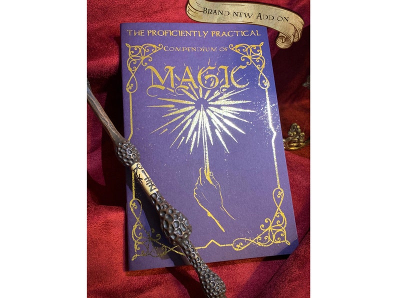 Deep purple book titled The Proficiently Practical Compendium of Magic with golden designs laid on a rich red fabric backdrop A detailed ornate wand rests diagonally atop the book. Above, a banner reads Brand new Add on. Ideal for magical enthusiasts