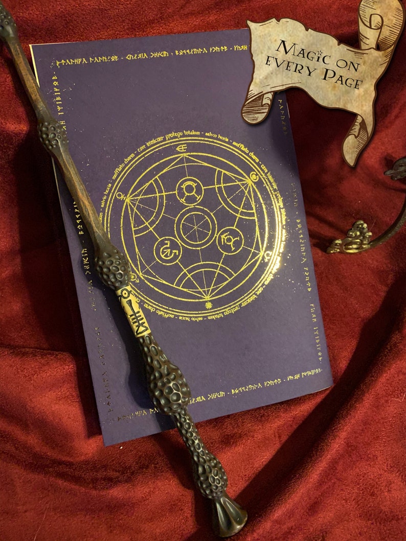 Purple book with intricate gold astral design on red velvet. A detailed wand lies beside it. Top banner reads 'Magic on Every Page'. Enchanting accessory for those passionate about the mystical arts.