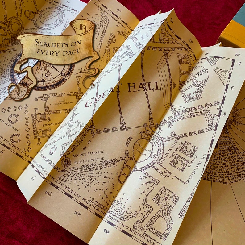 Folded parchment displaying intricate blueprints of a magical castle's interior. Details include rooms, hallways, and notes about secret passages. Centered is a banner that reads Secrets on Every Page. Background features a plush red fabric.