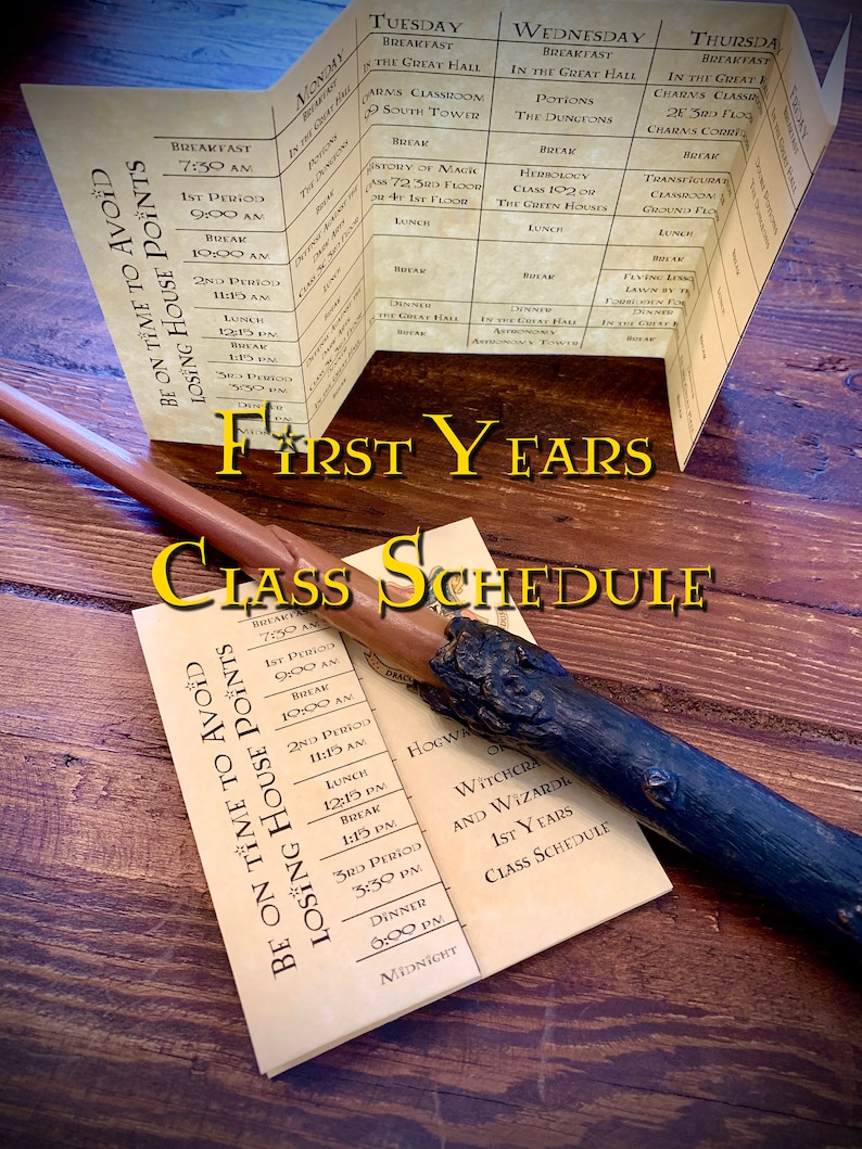 Folded parchment detailing a weekly class schedule for young magical learners. Displayed on a wooden surface, accompanied by a reddish quill and a dark wand with detailed crafting. Bolded text reads First Years Class Schedule.