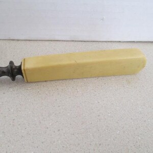Pu&ograve; includere: Un coltello da burro vintage in metallo e avorio con un manico lungo e rettangolare.