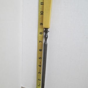 Pu&ograve; includere: Una lima per unghie vintage in metallo con un manico in plastica gialla. La lima &egrave; lunga circa 18 cm.