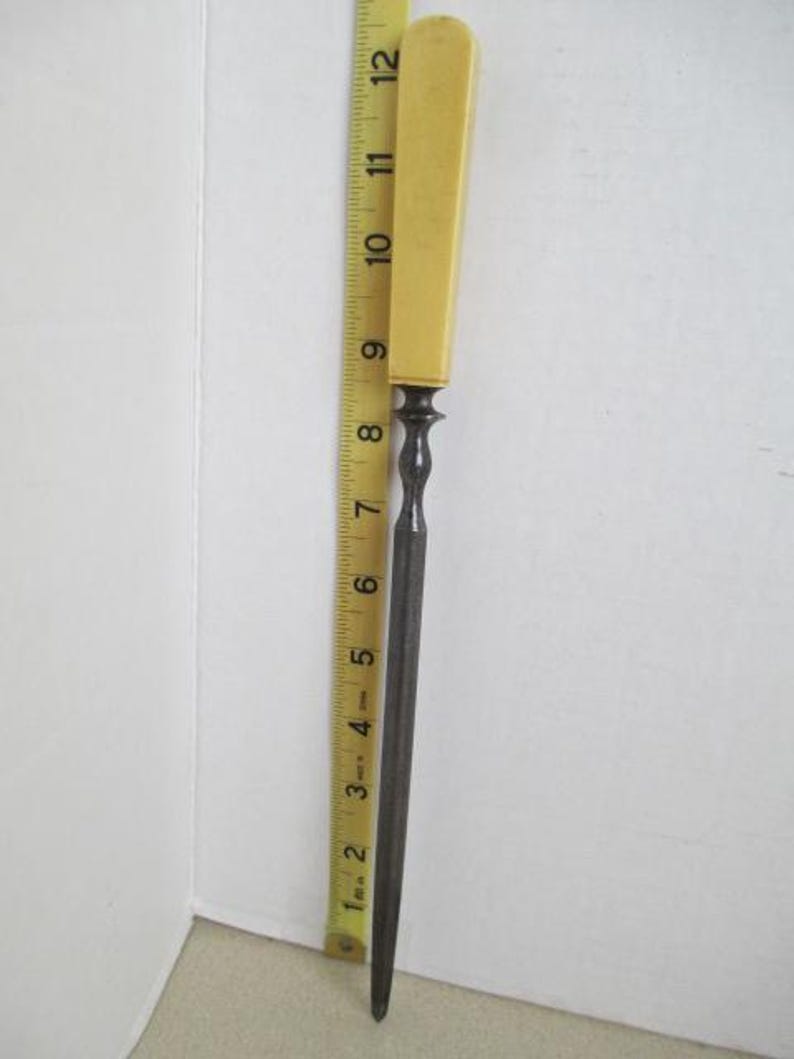 Pu&ograve; includere: Una lima per unghie vintage in metallo con un manico in plastica gialla. La lima &egrave; lunga circa 18 cm.