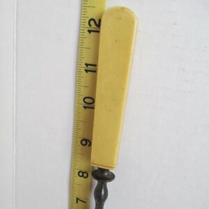 Pu&ograve; includere: Un apri-lettere vintage con manico in osso e asta in metallo. Il manico &egrave; di colore giallo pallido e l'asta &egrave; argentata.
