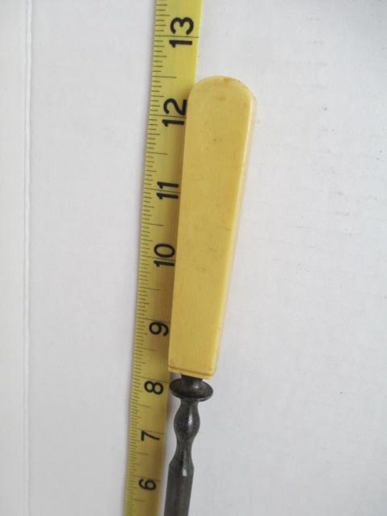 Pu&ograve; includere: Un apri-lettere vintage con manico in osso e asta in metallo. Il manico &egrave; di colore giallo pallido e l'asta &egrave; argentata.