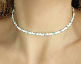 Halsband med vita pärlor och blått glas