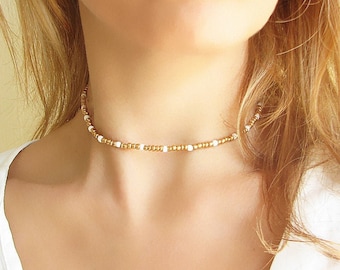 Collana girocollo con perline dorate e collana in vetro bianco