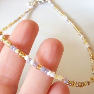 Dainty mix gold seed bead choker necklace made of 2.9mm glass seed beads. Length is 13 inches or 15 inches plus 2 inches extender chain. Closes with stainless steel lobster clasp.
