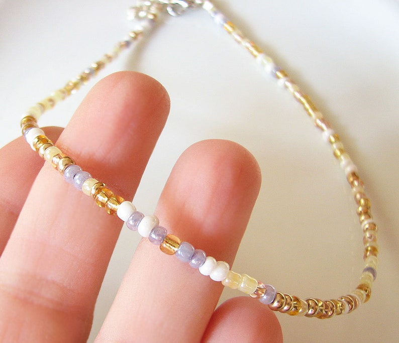 Dainty mix gold seed bead choker necklace made of 2.9mm glass seed beads. Length is 13 inches or 15 inches plus 2 inches extender chain. Closes with stainless steel lobster clasp.