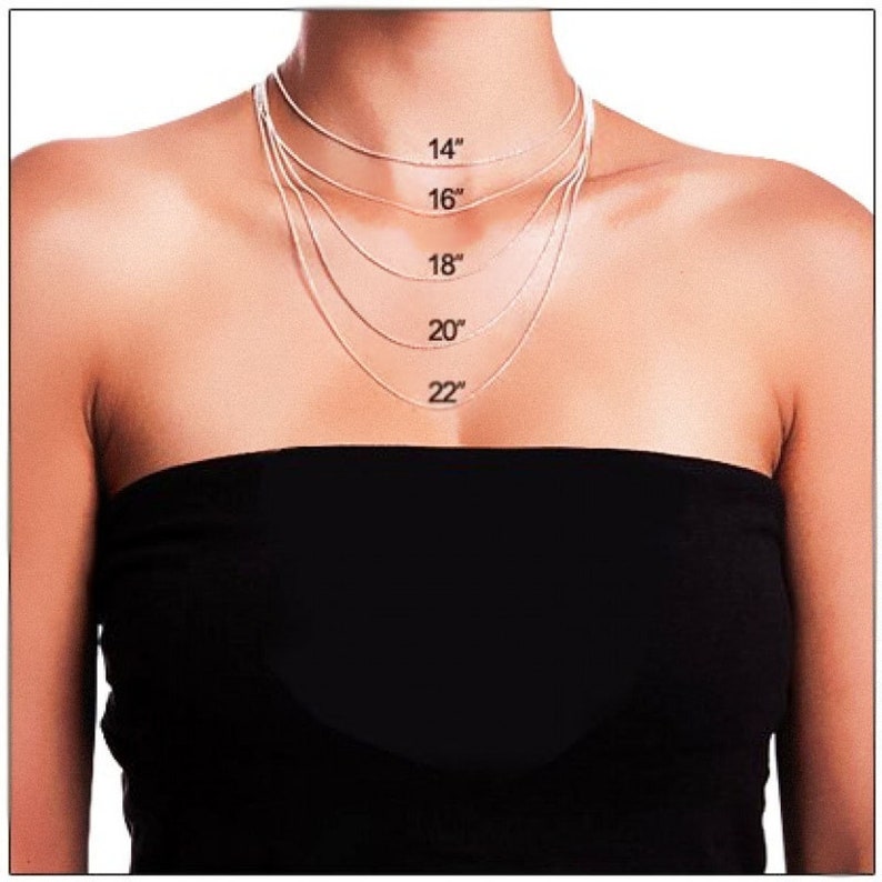 Puede incluir: Una modelo lleva una blusa negra con cinco cadenas plateadas de diferentes longitudes. Las cadenas est&aacute;n etiquetadas con sus longitudes en pulgadas: 14", 16", 18", 20" y 22".