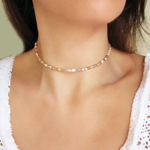 Dainty summer mix gold seed bead choker necklace made of 2.9mm glass seed beads. Length is 13 inches or 15 inches plus 2 inches extender chain. Closes with stainless steel lobster clasp.