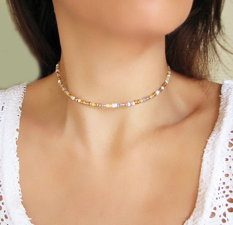 Dainty summer mix gold seed bead choker necklace made of 2.9mm glass seed beads. Length is 13 inches or 15 inches plus 2 inches extender chain. Closes with stainless steel lobster clasp.