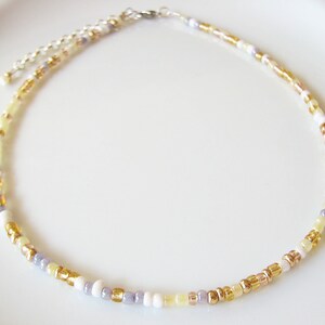 Dainty mix gold seed bead choker necklace made of 2.9mm glass seed beads. Length is 13 inches or 15 inches plus 2 inches extender chain. Closes with stainless steel lobster clasp.