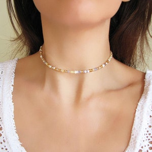 Dainty mix gold seed bead choker necklace made of 2.9mm glass seed beads. Length is 13 inches or 15 inches plus 2 inches extender chain. Closes with stainless steel lobster clasp.