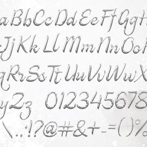 Pu&ograve; includere: Un set completo di lettere dell'alfabeto, numeri e simboli argentati in corsivo. Le lettere sono sia maiuscole che minuscole, con un aspetto lucido e metallico. Lo sfondo &egrave; bianco e strutturato.