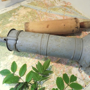 Peut inclure: Un hachoir à saucisses vintage en métal bleu avec un pilon en bois. Le hachoir est sur une carte avec une rivière et le mot "Vienne" visible.