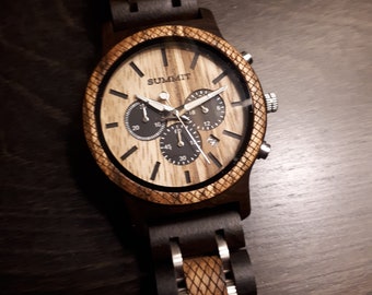 May include: A wristwatch featuring a dark wood and light wood grain face with the word SUMMIT printed in black. The watch includes three black sub-dials, silver hands, and a date window. The bezel and bracelet links alternate between dark and light wood.
