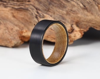 Anillo de tungsteno negro con banda interior de madera de barril de whisky.