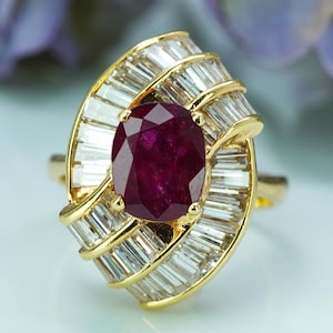 Puede incluir: Anillo de oro con un rubí ovalado central, rodeado de diamantes talla baguette. El diseño del anillo es clásico y elegante. El rubí es de color rojo intenso, los diamantes son claros y brillantes. Una joya preciosa.