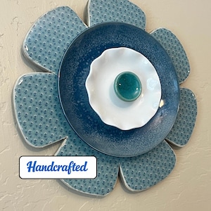 Handcut wood flower wall decor with blue and white plates, ceramic knob, clear gloss epoxy finish. Indoor hanging art.