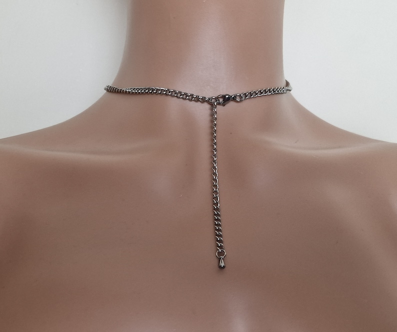 May include: A silver chain necklace with a lobster clasp closure. The chain is adjustable and has a drop-shaped pendant at the end.
