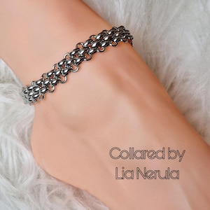 May include: A silver chain anklet with a layered design. The anklet is on a person's ankle. The text "Collared by Lia Nerula" is visible in the image.
