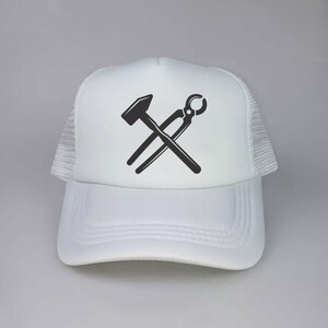 May include: White trucker hat with a black silhouette of a hammer and pliers crossed over each other.
