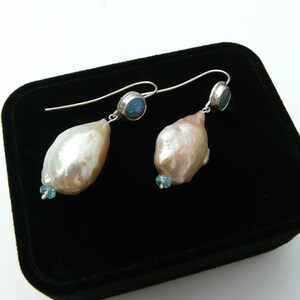 May include: A pair of silver earrings with a baroque pearl and a blue opal gemstone on each earring.