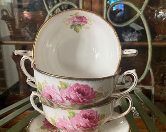 May include: A set of three vintage teacups and saucers with a floral pattern featuring pink roses. The cups and saucers have a gold trim.