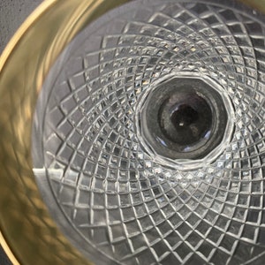 May include: A close-up of the inside of a clear glass goblet with a gold rim. The glass has a diamond-shaped pattern.