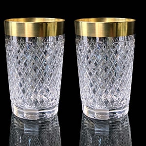 May include: Two clear glass tumblers with a gold rim. The glasses have a diamond pattern.